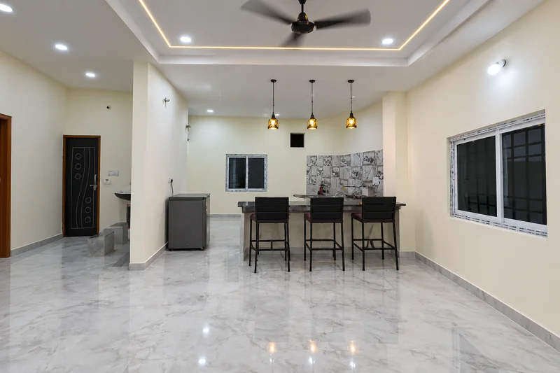 Kitchen counter and dining stools beside the indoor living area — AI recreation from supplied reference