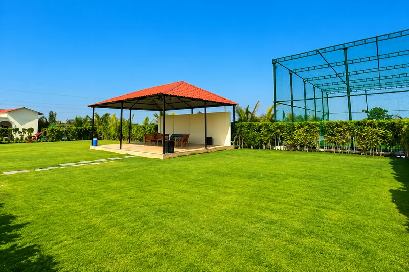 Spacious lawn with a covered outdoor seating pavilion and BBQ area — AI recreation from supplied reference