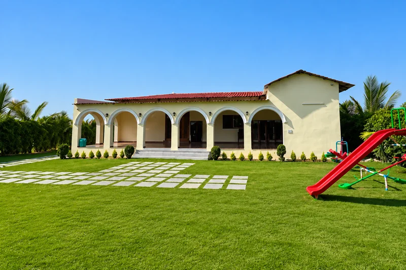 Arched veranda of the main residence facing the green lawn — AI recreation from supplied reference